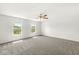 Bright bedroom with a ceiling fan, two large windows, and neutral carpet at 8910 Youngs Creek Ln, Indianapolis, IN 46113