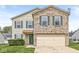 Two-story home featuring brick and vinyl siding, a two-car garage and well-maintained landscaping at 8910 Youngs Creek Ln, Indianapolis, IN 46113
