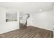 Open floor plan featuring gray wood floors, neutral walls, and a carpeted staircase at 8910 Youngs Creek Ln, Indianapolis, IN 46113