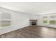 Bright living room featuring gray wood floors, neutral walls, a brick fireplace and two windows at 8910 Youngs Creek Ln, Indianapolis, IN 46113