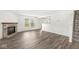 Open floor plan featuring gray wood floors, neutral walls, a fireplace and a carpeted staircase at 8910 Youngs Creek Ln, Indianapolis, IN 46113