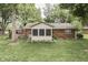 Well-maintained backyard with a brick house featuring a sunroom and lush green lawn at 912 Ramblin Rd, Greenwood, IN 46142