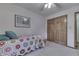 Bedroom featuring twin size bed with floral coverlet, ceiling fan, wood door and walls with decorative wallpaper at 912 Ramblin Rd, Greenwood, IN 46142