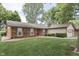 Traditional-style home features a red front door, brick facade, and well-manicured lawn and mature shade trees at 912 Ramblin Rd, Greenwood, IN 46142