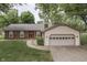 Charming single-story home features a brick facade, attached garage, and mature trees in the front yard at 912 Ramblin Rd, Greenwood, IN 46142