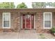 Close-up of the home's entry featuring a red door with glass inserts and brick and tan siding at 912 Ramblin Rd, Greenwood, IN 46142