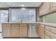Well-maintained kitchen with stainless steel dishwasher, wood cabinets, and natural light from the window at 912 Ramblin Rd, Greenwood, IN 46142