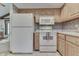 Functional kitchen with white appliances, light wood cabinetry, and neutral countertops at 912 Ramblin Rd, Greenwood, IN 46142