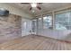 Sunroom with wood floor, ceiling fan, multiple windows and brick wall with sliding glass doors at 912 Ramblin Rd, Greenwood, IN 46142