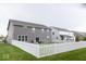 Spacious backyard featuring a white picket fence, lush lawn, and a patio with outdoor seating at 9176 Springbrook Dr, Pendleton, IN 46064