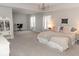 Large, well-lit main bedroom with desk, bookshelves, chandelier, and decorative curtains at 9176 Springbrook Dr, Pendleton, IN 46064