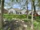 Lush backyard featuring a stone walkway, vibrant flowerbeds, and a patio dining area for outdoor enjoyment at 9653 Woodsong Way, Indianapolis, IN 46229