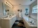 Bright bathroom with double sinks, bathtub and decorative accents at 9653 Woodsong Way, Indianapolis, IN 46229