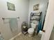 Well-lit half bath with standard toilet, towel rack, and open shelving at 9653 Woodsong Way, Indianapolis, IN 46229