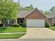 Charming brick home featuring a well-manicured lawn and a spacious two-car garage at 9653 Woodsong Way, Indianapolis, IN 46229