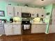 Updated kitchen featuring stainless steel appliances, white cabinetry, granite counters, and modern fixtures at 9653 Woodsong Way, Indianapolis, IN 46229