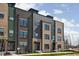 Contemporary townhome showcasing a modern brick facade with large windows, and a beautifully landscaped lawn at 9891 Baneberry Ln, Carmel, IN 46290