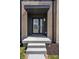 Stylish front door with glass panels, a covered entryway, and a modern brick facade create a welcoming entrance at 9891 Baneberry Ln, Carmel, IN 46290