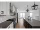 Modern kitchen features gray countertops, white cabinets, stainless steel appliances, and pendant lighting at 9891 Baneberry Ln, Carmel, IN 46290