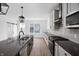 Bright, modern kitchen featuring a large island, gray countertops, pendant lighting and stainless steel appliances at 9891 Baneberry Ln, Carmel, IN 46290