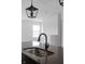 Modern kitchen island detail featuring a black faucet and gray countertops, with pendant lighting above at 9891 Baneberry Ln, Carmel, IN 46290