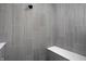 Modern walk-in shower with gray tiling, sleek design, and a built-in bench at 9891 Baneberry Ln, Carmel, IN 46290