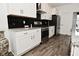 Contemporary kitchen featuring stainless steel appliances, stylish black backsplash, and wood-look flooring at 9928 Deep Royal Way, Indianapolis, IN 46239