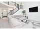 Open living room with a large gray sectional, wrought iron staircase, and large TV at 9928 Deep Royal Way, Indianapolis, IN 46239