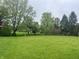 Expansive green lawn with mature trees, offering privacy and space for outdoor activities at 10118 Leeward Blvd, Indianapolis, IN 46256