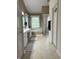 Bright bathroom with a double vanity, a soaking tub under a window and tiled floors at 10118 Leeward Blvd, Indianapolis, IN 46256