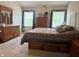 Spacious bedroom showcasing a wooden dresser, a large bed and two sunny windows at 10118 Leeward Blvd, Indianapolis, IN 46256