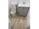 Powder room features a white toilet, vanity with a sink and wood floors at 10361 E 30Th St, Indianapolis, IN 46229