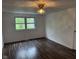 Bright bedroom featuring a ceiling fan, neutral walls, window, and dark laminate flooring at 10361 E 30Th St, Indianapolis, IN 46229