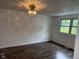 Cozy bedroom with dark flooring, neutral walls, and a window overlooking the outdoors at 10361 E 30Th St, Indianapolis, IN 46229