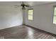 Large bedroom with wood-look floors, ceiling fan, and two windows at 10361 E 30Th St, Indianapolis, IN 46229