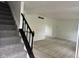 Open entryway with wood flooring and a carpeted staircase featuring a dark wood railing at 10361 E 30Th St, Indianapolis, IN 46229