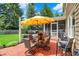 Outdoor patio area with table, chairs, and umbrella next to a screened-in porch and lush green lawn at 10882 Camden Ct, Fishers, IN 46038