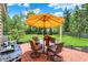 Outdoor patio area with brick flooring, seating, and a bright yellow umbrella for shade at 10882 Camden Ct, Fishers, IN 46038