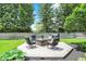 Manicured backyard with a deck and comfortable seating arranged around a wooden coffee table and a grill at 10882 Camden Ct, Fishers, IN 46038