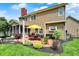 Backyard view of a two-story house with a brick patio, screened porch, and well-maintained landscaping at 10882 Camden Ct, Fishers, IN 46038