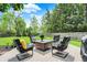 Well-manicured backyard features a deck with cushioned chairs surrounding a wooden coffee table at 10882 Camden Ct, Fishers, IN 46038