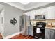 An updated kitchen includes stainless steel appliances, granite counters, and bright white cabinets at 10882 Camden Ct, Fishers, IN 46038