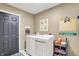 Laundry room with washer, dryer, storage, and a dark gray accent door at 10882 Camden Ct, Fishers, IN 46038