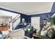 Stylish living room with blue walls, neutral carpet, and an open layout to the foyer at 10882 Camden Ct, Fishers, IN 46038