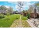 Spacious backyard featuring a stone pathway, green grass, a small shed and partially shaded seating area at 10935 Cornell St, Carmel, IN 46280