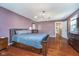 Bedroom featuring hardwood floors, dark wood furniture and modern light fixture at 10935 Cornell St, Carmel, IN 46280