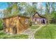 Exterior shot of a wooden shed and outbuilding with a stone pathway amid a lush green lawn at 10935 Cornell St, Carmel, IN 46280