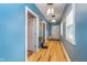 Bright hallway with hardwood floors and blue painted walls at 10935 Cornell St, Carmel, IN 46280