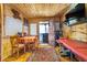 Comfortable living area featuring wooden walls and ceiling, a dining table, massage table, and sauna access at 10935 Cornell St, Carmel, IN 46280