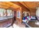 Cozy covered porch with a hot tub, comfortable seating, and wood paneled walls and ceilings at 10935 Cornell St, Carmel, IN 46280